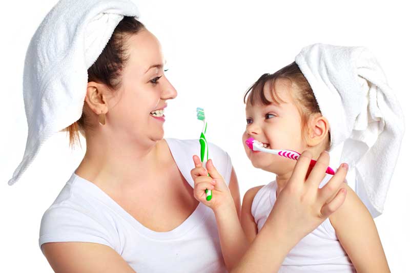 Happy Mother and Daughter Brushing Their Teeth